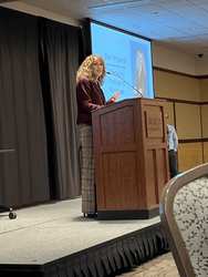 Expert Woman Presenter Speaking At Crescendo Consulting Event On Stage.