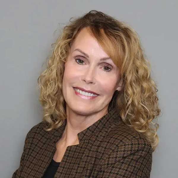 Professional Business Consultant With Curly Blonde Hair, Smiling In A Corporate Setting.