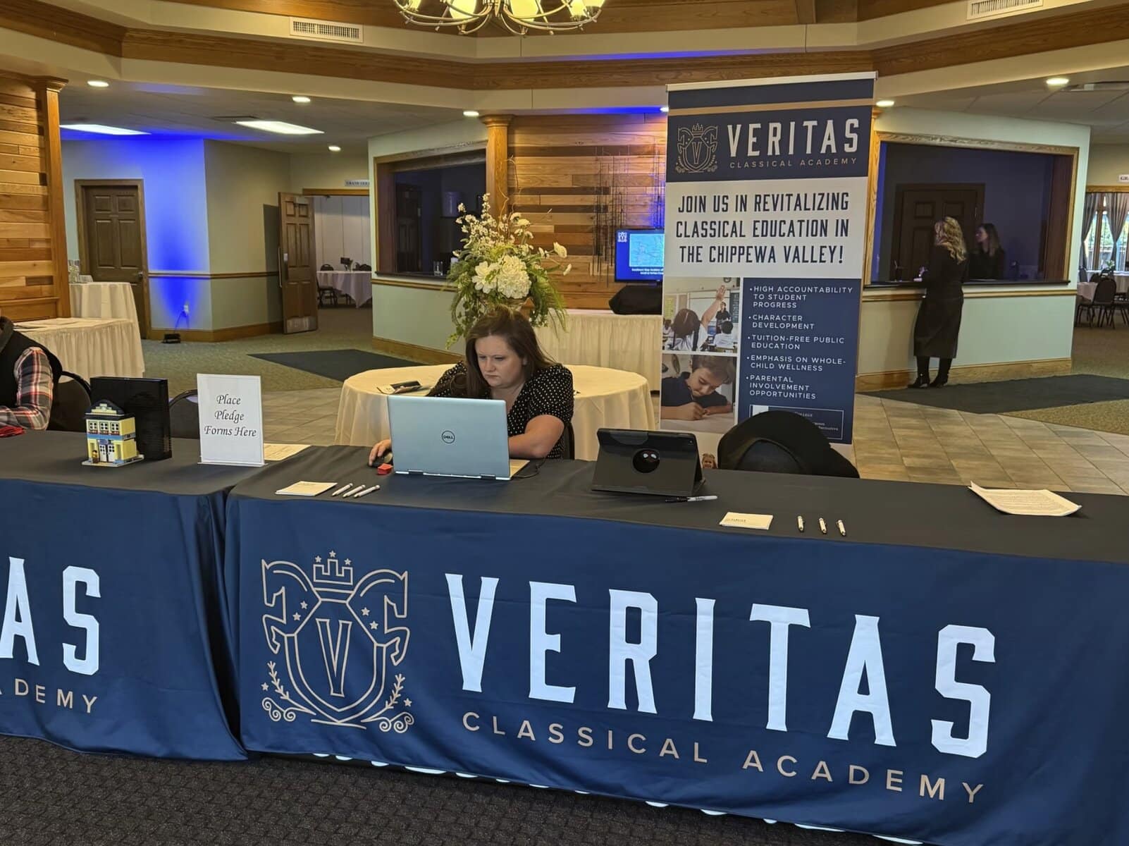 Conference Registration Desk With Veritas Classical Academy Banner At An Educational Event.